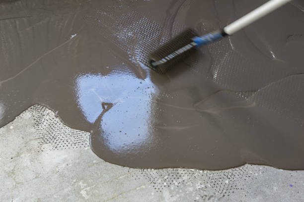 istock Spreading self leveling plaster with a special roller. Interior of apartment under construction 831617448