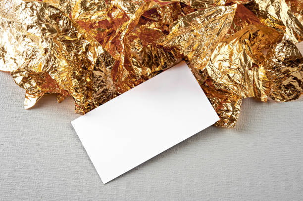 istock Gold background. White card on the gold leaf texture. 831617658