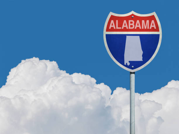 istock Highway sign for Interstate road in Alabama with map in front of clouds 831618296