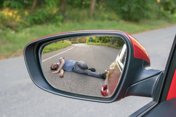 hit and run concept. view on injured man on road in rear mirror of a car. - hit and run imagens e fotografias de stock