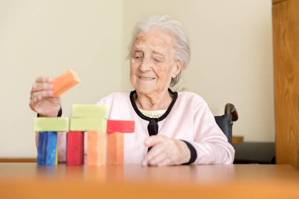 istock Senior woman playing with wooden blocks 831621734