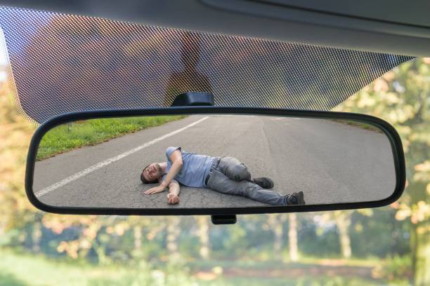 hit and run concept. view on injured man on road in rear mirror of a car. - hit and run imagens e fotografias de stock