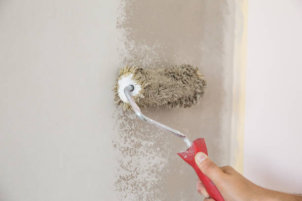 istock Man with a roller in his hand paints the wall 831622026