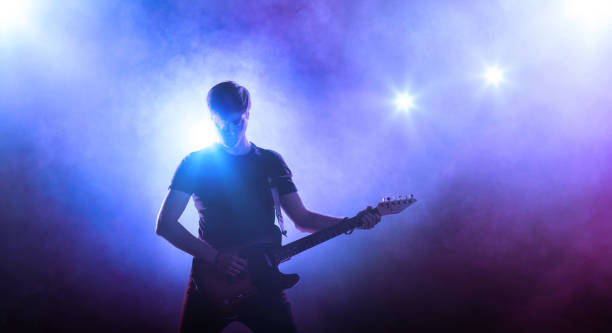 istock Guitar player on stage holding a guitar 831622296