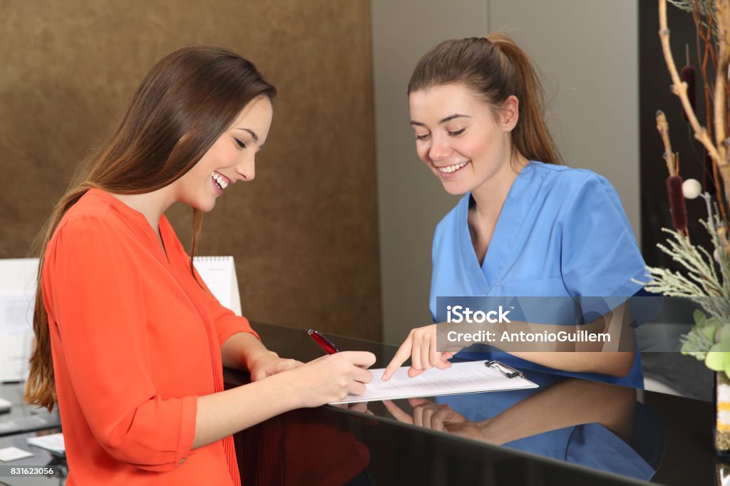 Patient being attended in a medical consultation Patient being attended by a nurse in a medical consultation Receptionist Stock Photo