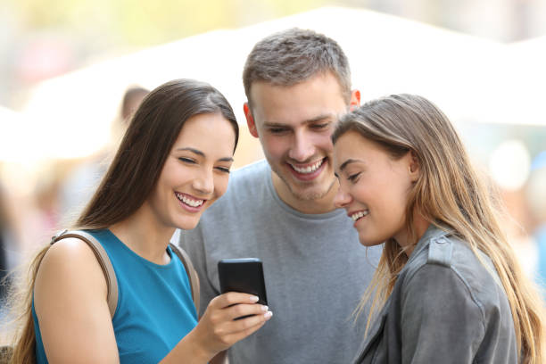 istock Friends sharing phone content on the street 831625500