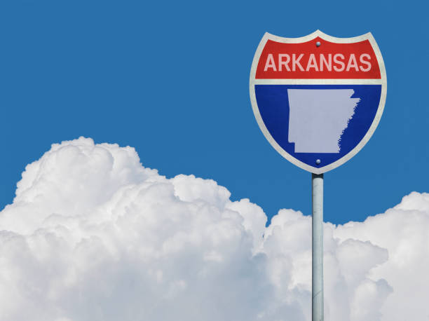 istock Highway sign for Interstate road in Arkansas with map in front of clouds 831625926