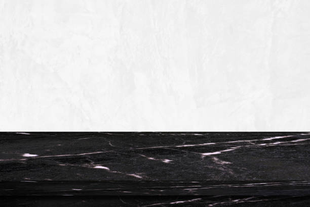 istock Empty black marble table over white cement wall background, product display montage 831626746