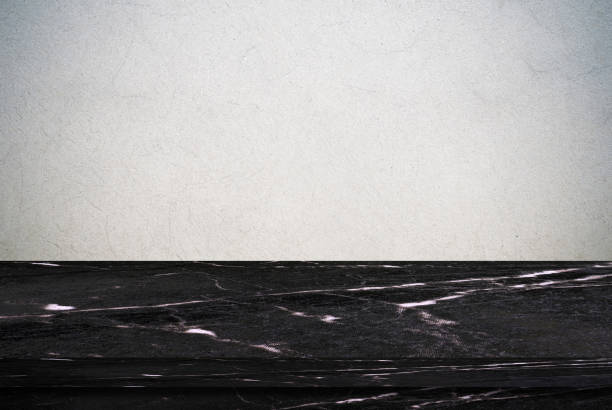 istock Empty black marble table over gray cement wall background, product display montage 831627272