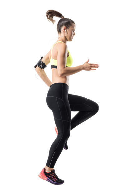 istock Frozen motion of fit female athletic runner doing high knees warm up exercise. 831630834