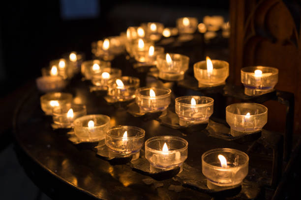istock Candles in church with dark background 831630998