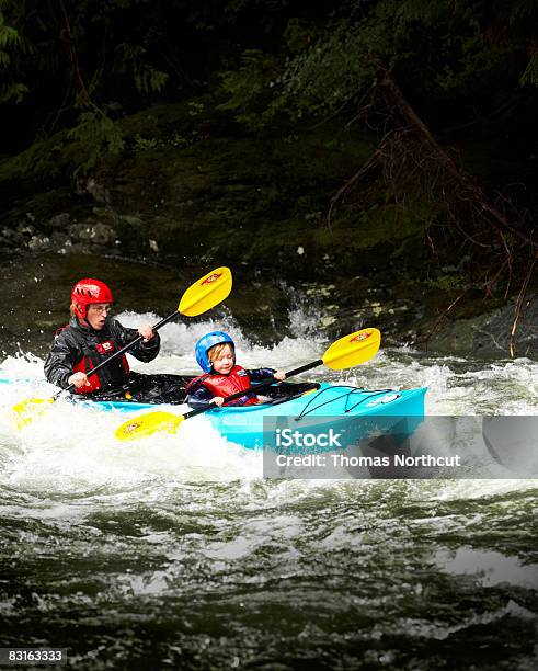 Father And Son Kayaking Through Rapids Stockfoto en meer beelden van Kajakken - Kajakken, Kind, Rivier