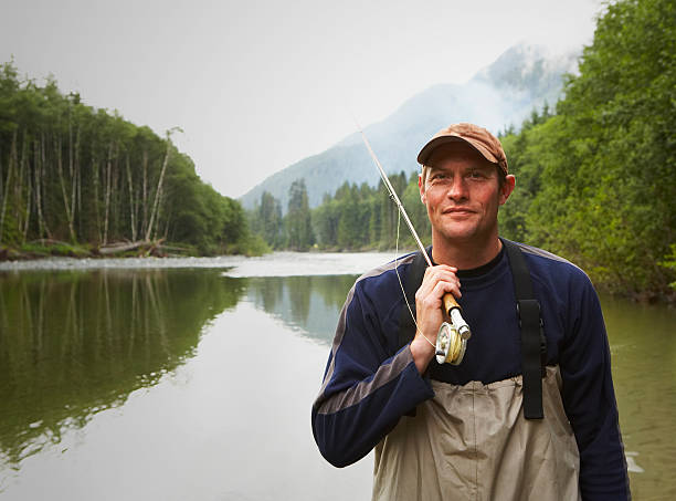 porträt von fly fisherman, steht im river - fly fishing fishing river fisherman stock-fotos und bilder