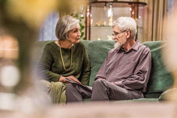 istock Senior couple sitting on sofa 831635102