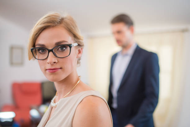 A businessman holding his hand on a businesswoman back isolated on a white background