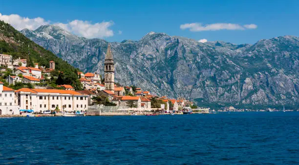 The bell tower of St Nicholas Church and the village of  Perast in Montenegro. Perast is a beautiful village that sits on the bay of Kotor on the adriatic sea.