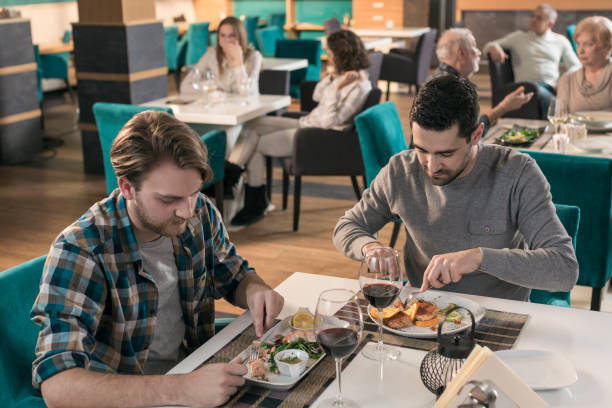 istock Two man having lunch in restaurant 831639164