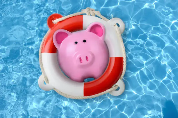 Piggy bank in a lifebuoy concept of financial rescue