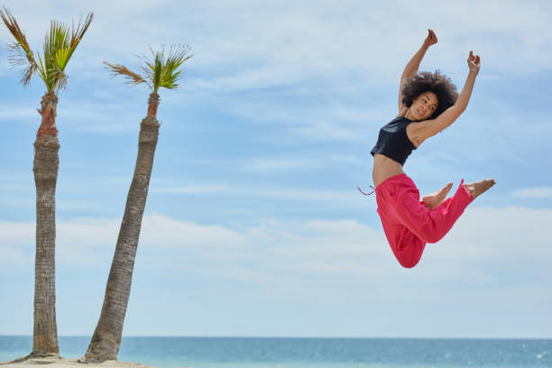 istock Young pretty sportswoman dancing jumping on beach 831652868