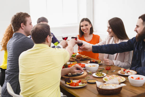 istock People say cheers clink glasses at festive table dinner party 831653732