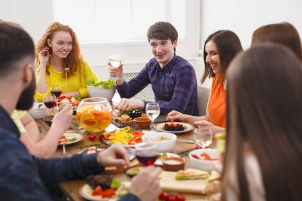 istock Group of happy people at festive table dinner party 831655810
