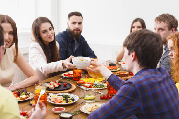 istock Group of happy people at festive table dinner party 831655856
