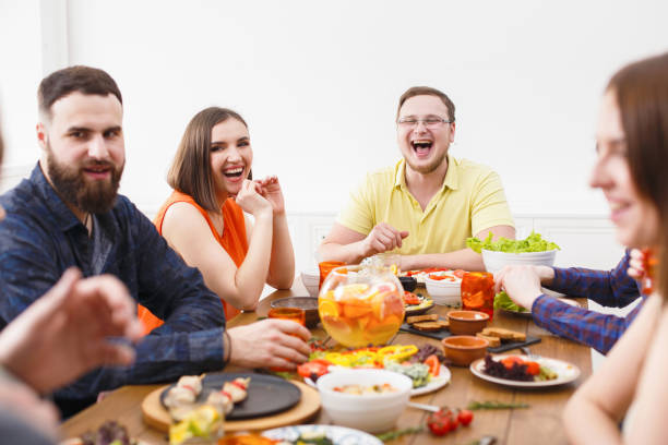 istock Group of happy people at festive table dinner party 831655914