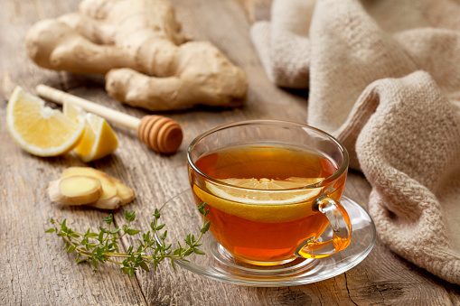 tea with ginger, lemon and thyme on old wooden background