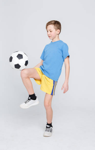 istock Boy in casual with soccer ball at white studio background 831656816