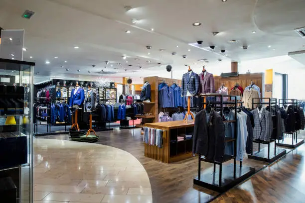 Interior of a high-quality clothing shop for men with many suits and neckties on display