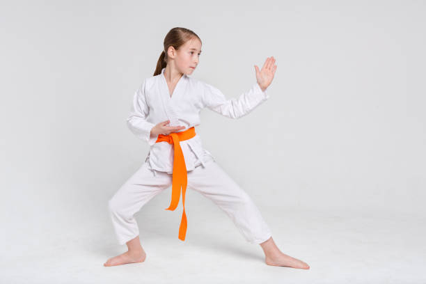niña de karate kimono en el stand de fondo de estudio - karate child judo belt fotografías e imágenes de stock