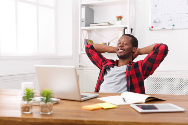 istock Relaxed black businessman with laptop in modern white office 831662048