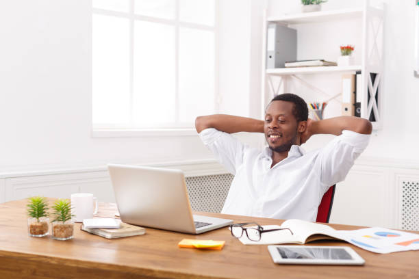 istock Young relaxed businessman with laptop in modern white office 831662380
