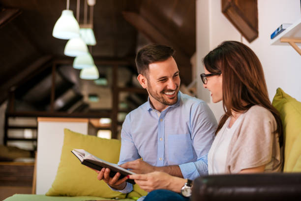 istock Beautiful young loving couple bonding to each other and smiling while reading book 831664744
