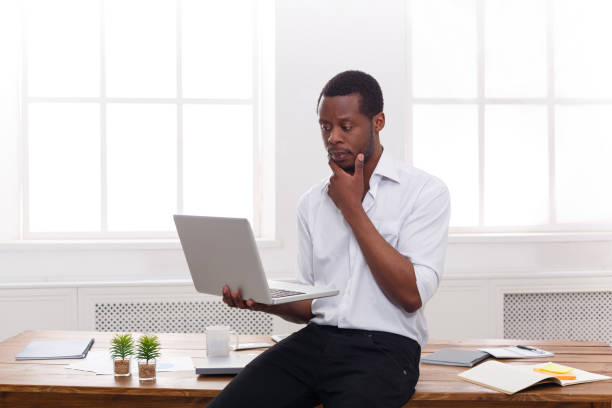 istock Thoughtful black businessman in casual office, work with laptop 831664824