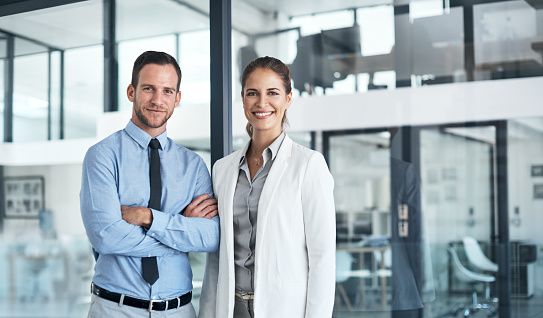 Cropped portrait of two businesspeople standing side by side in their office