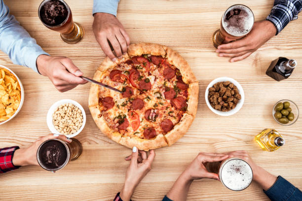 istock friends eating pizza together 831668010