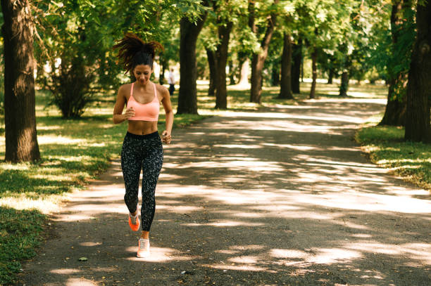 istock Fit woman running outdoors in park on a sunny day 831668998