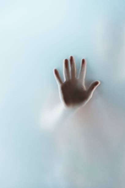 istock cropped view of human hand touching glass, selective focus 831679826