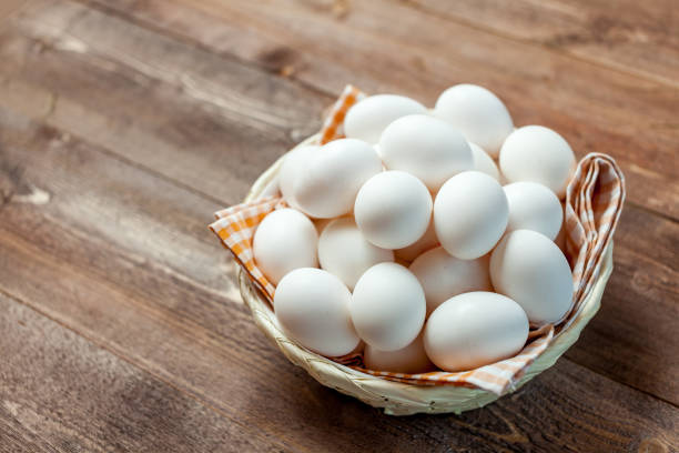istock Chicken eggs in basket on wooden background 831683214