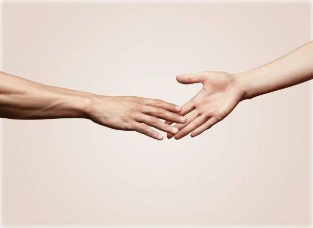 Hands of man and woman reaching to each other