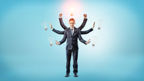 istock A businessman with many hands surrounded by light bulbs with one of them lighted up 831683878
