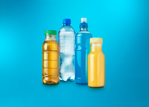 Mineral water in small plastic bottles on yellow background. Top view. Flat lay