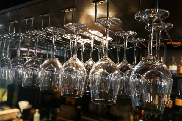 istock Empty wine glasses hanging on rack in bar 831689044