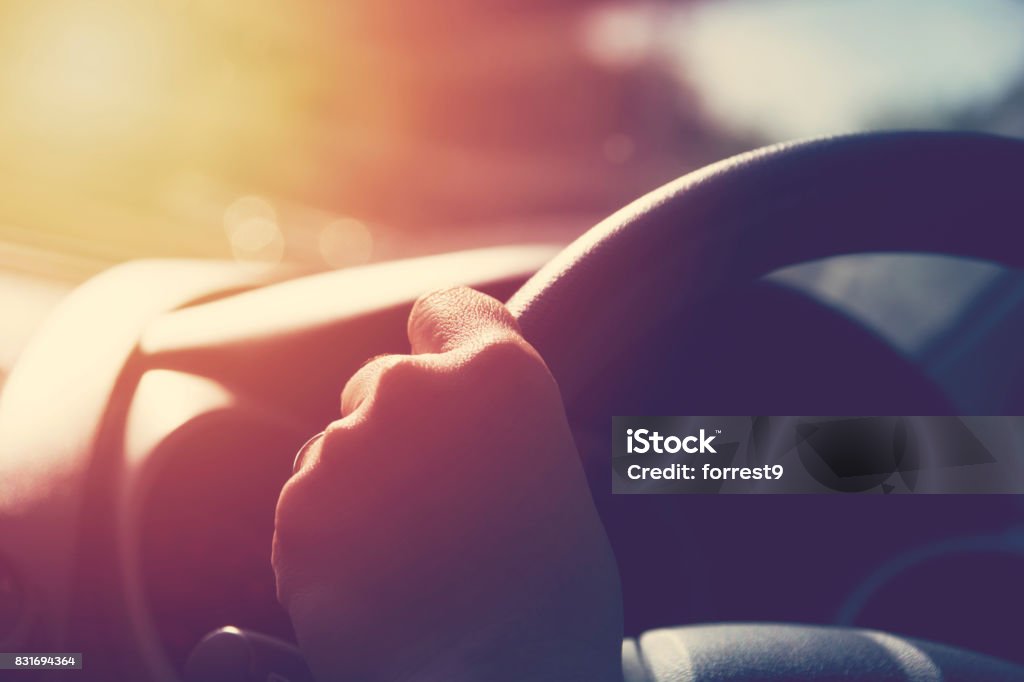 Mano femenina en la rueda de manejo. Concepto de viaje y seguridad. - Foto de stock de Volante libre de derechos