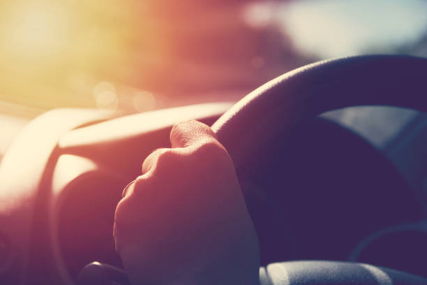 mano femminile sul volante. concetto di viaggio e safty. - steering wheel foto e immagini stock