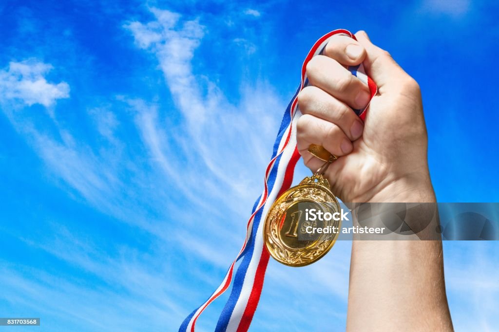 Medal. Gold medal with  ribbon  in hand on  background Achievement Stock Photo