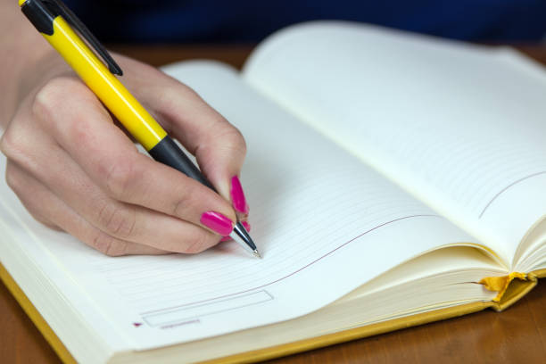 istock Beautiful woman sitting at her working place and writing something in her notebook. 831704510