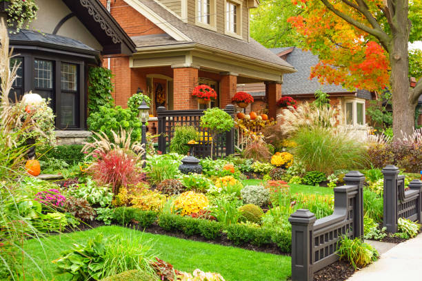 Bright flowers overflow a red wheelbarrow in a peaceful, sunny garden setting.