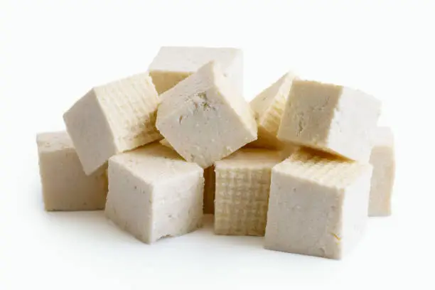 Cubes of cut white tofu isolated on white.